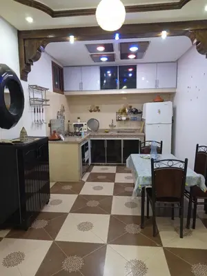 a large kitchen with a table and a table and a table and chairs at Farah in Oulad Akkou