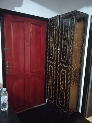 two red and black doors in a room at Calme in Oulad Akkou