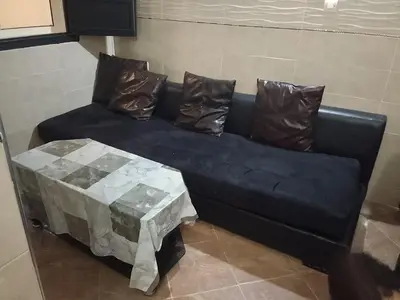 a blue couch with two pillows and a table at Calme in Oulad Akkou