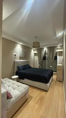 a bedroom with a bed and a couch at Comfortable and charming apartment in Oulad Akkou