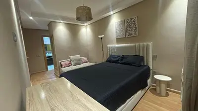 a bedroom with a bed and a couch at Comfortable and charming apartment in Oulad Akkou