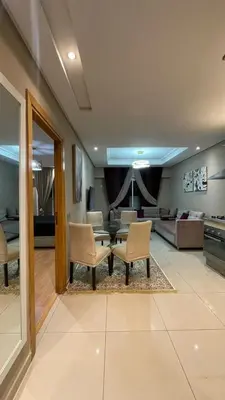 a living room with a couch and a table and chairs at Comfortable and charming apartment in Oulad Akkou