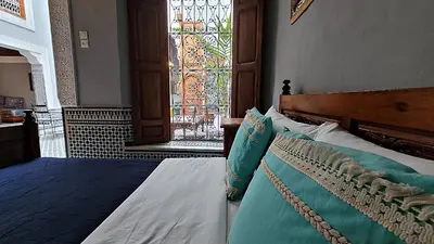 a bedroom with a bed and a stained glass window at Riad Dar Bahija Fes in Fès
