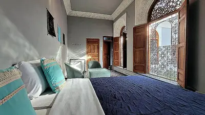 a bedroom with a bed and a large window at Riad Dar Bahija Fes in Fès