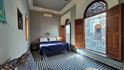 a bedroom with a bed and a large window at Riad Dar Bahija Fes in Fès