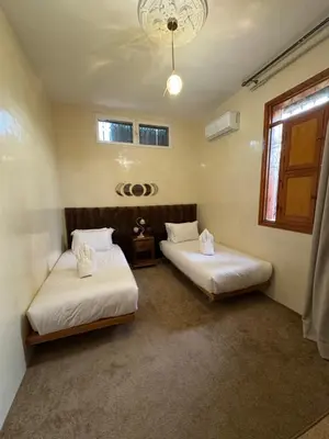 two beds in a room with at Maison Dar Rima in Aït Ali Ou Allah