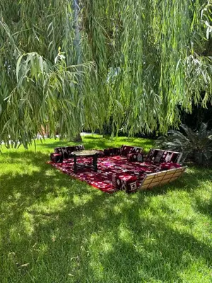 a picnic table and a bench on a blanket in the grass at Maison Dar Rima in Aït Ali Ou Allah