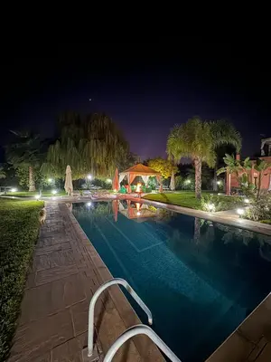 a swimming pool at night with a house at Maison Dar Rima in Aït Ali Ou Allah