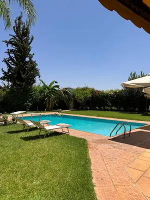 a swimming pool with two chairs and a table at Maison Dar Rima in Aït Ali Ou Allah