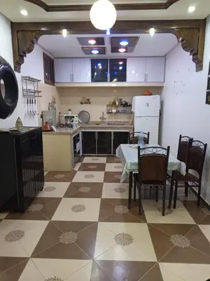 a kitchen with a table and chairs and a table and a kitchen at El farah in Oulad Akkou