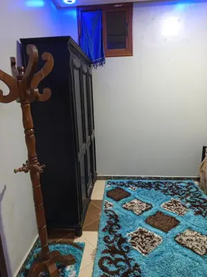 a room with a black cabinet and a blue rug at El farah in Oulad Akkou