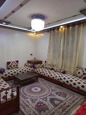 a living room with a couch and a rug at El farah in Oulad Akkou
