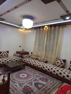 a living room with a couch and a rug at El farah in Oulad Akkou