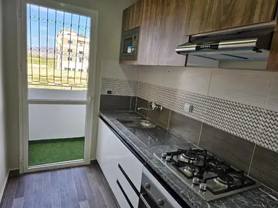 a kitchen with a stove and a window in it at Cosy appartement in Oulad Akkou