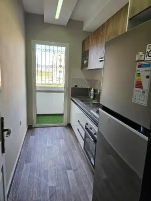 a kitchen with a stainless steel refrigerator and a window at Cosy appartement in Oulad Akkou