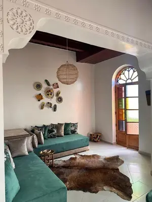 a living room with a green couch and a table at Dar Kenza in Fès