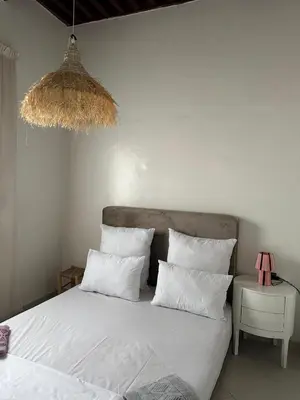 a bed with white sheets and pillows in a bedroom at Dar Kenza in Fès