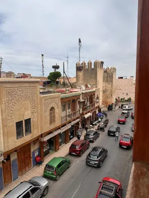 a busy city street with cars parked on the street at Dar Kenza in Fès