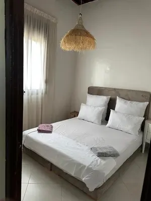 a bedroom with a large white bed with a chandelier at Dar Kenza in Fès