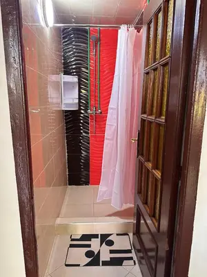 a bathroom with a shower with a red door at Dar Kenza in Fès
