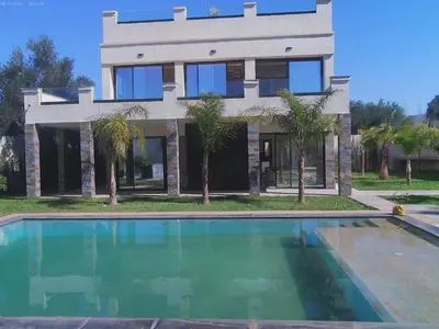 a house with a swimming pool in front of a house at Villa Ghmat in Aït Ali Ou Allah