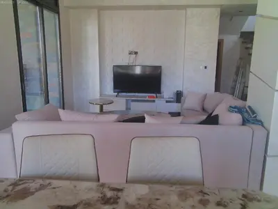 a white couch in a living room with a television at Villa Ghmat in Aït Ali Ou Allah
