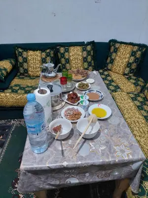 a table with plates of food on a couch at imintanoute abderrahim in Oulad Akkou