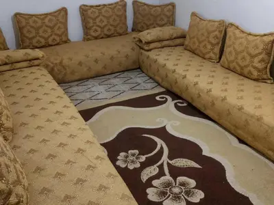 a couch sitting in a living room with a rug at imintanoute abderrahim in Oulad Akkou