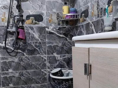 a bathroom with a shower with a stone wall at imintanoute abderrahim in Oulad Akkou