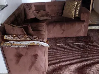 a brown couch with pillows on it in a room at imintanoute abderrahim in Oulad Akkou