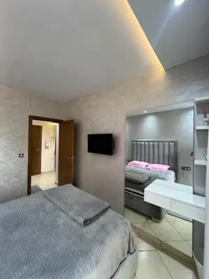 a bedroom with a bed and a sink and a mirror at Maison in Oulad Akkou