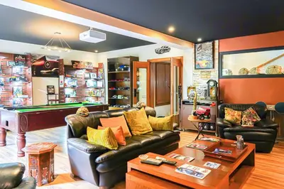 a living room with a leather couch and a pool table at The Classic Affair For Car Lovers in Oulad Akkou