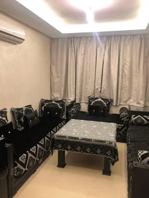 a living room with chairs and a table and a window at Appartement Nour sakane targa kech in Oulad Akkou