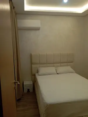 a bedroom with a bed with a light above it at Appartement Nour sakane targa kech in Oulad Akkou