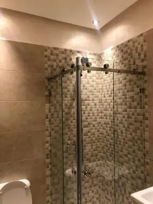 a shower with a glass door in a bathroom at Appartement Nour sakane targa kech in Oulad Akkou