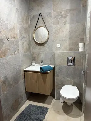 a bathroom with a sink and a toilet and a mirror at Duplex confortable in Oulad Akkou