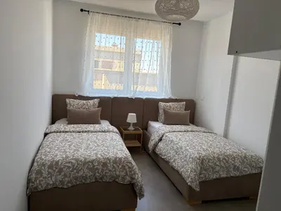 two beds in a small room with a window at Duplex confortable in Oulad Akkou
