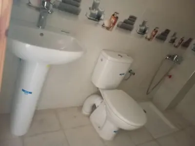 a bathroom with a white toilet and a sink at Appartement chic fes in Oulad Akkou