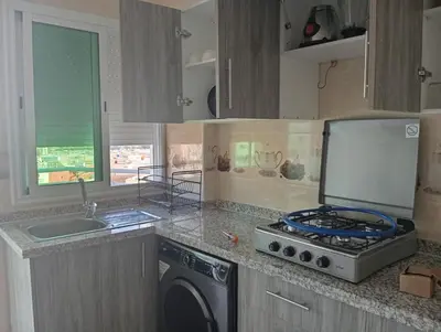 a kitchen with a stove and a washing machine at Appartement chic fes in Oulad Akkou
