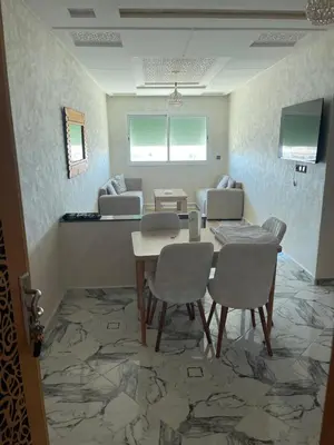 a dining room with a table and four chairs at Appartement chic fes in Oulad Akkou