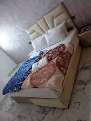a bed in a cardboard box with a bedspread and pillows at Appartement chic fes in Oulad Akkou