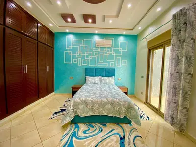 a bedroom with a bed with a blue wall at Villa Rania Le luxe à Marrakech in Ourika