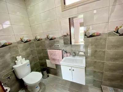 a bathroom with a toilet and a sink and a mirror at Villa Rania Le luxe à Marrakech in Ourika