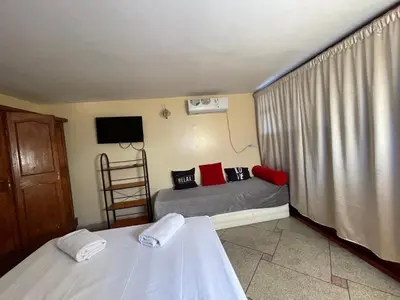 a bedroom with two beds and a tv and a ladder at Hotel Maison Olga in Meknès