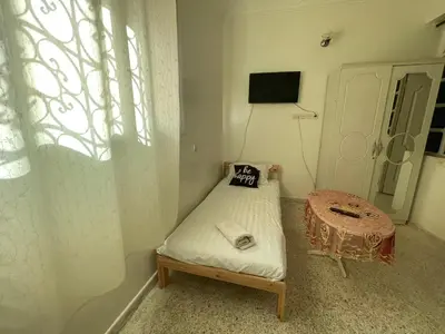 a small room with a bed and a table at Hotel Maison Olga in Meknès