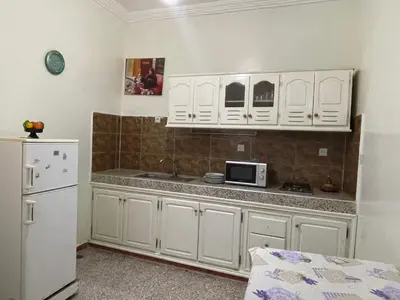 a kitchen with white cabinets and a white refrigerator at Hotel Maison Olga in Meknès