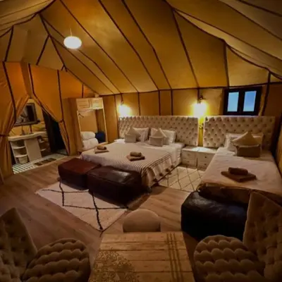 a bedroom with two beds in a tent at Moha Luxury Camp in Merzouga