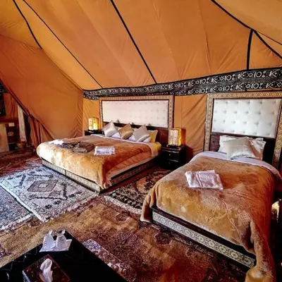 a bedroom with two beds in a tent at Moha Luxury Camp in Merzouga