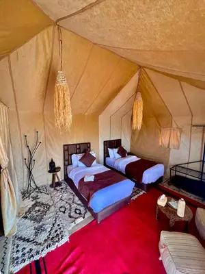 a bedroom with two beds in a tent at Moha Luxury Camp in Merzouga