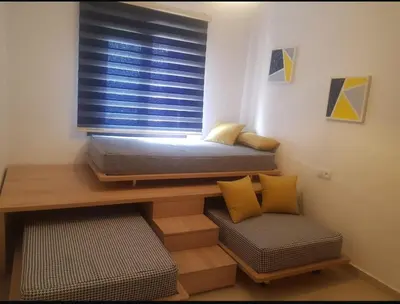 a bedroom with a bed and a window with a chair at Cosy appartement in Oulad Akkou